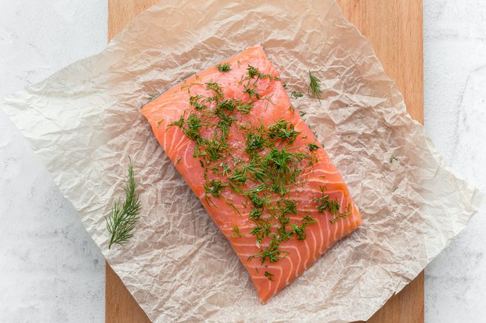 Salmon steak with dill and salt on a cooking paper