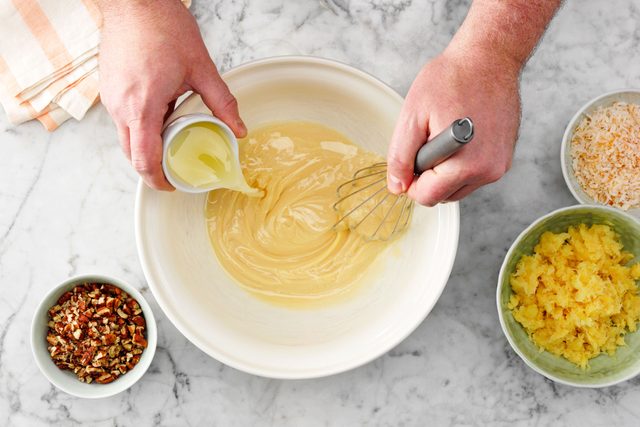 hand with a whisk beating lemon juice and milk together