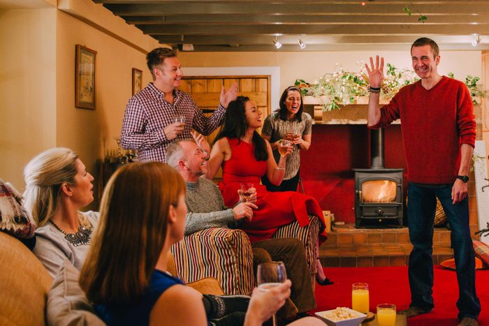 Group Of Friends Play Charades At An Engagement Party Indoors In A Living Room