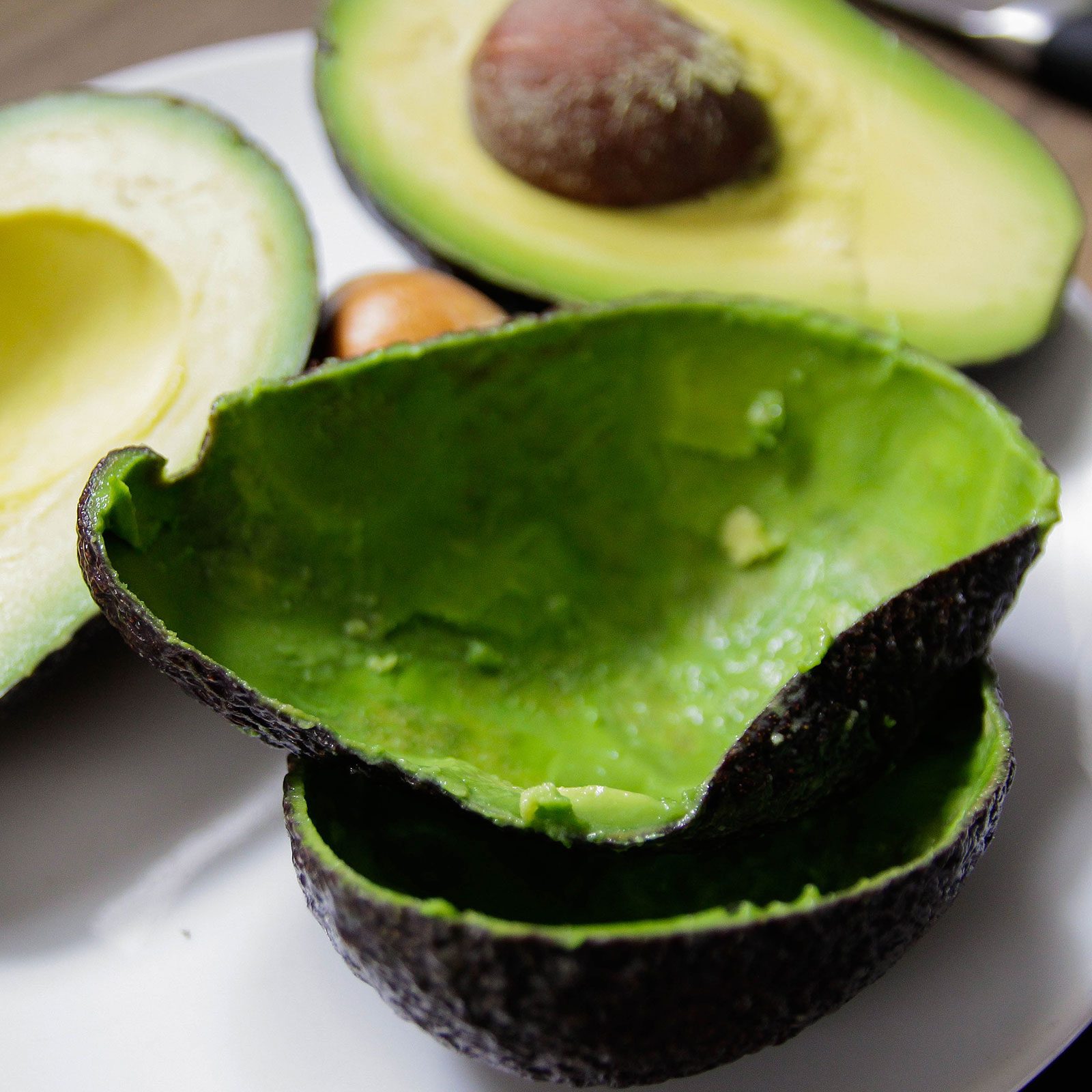 Avocado Skins and Pit on a plate out of focus on a bright background