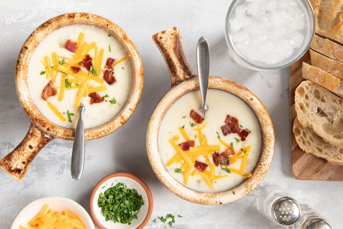 two bowls of potato soup topped with bacon