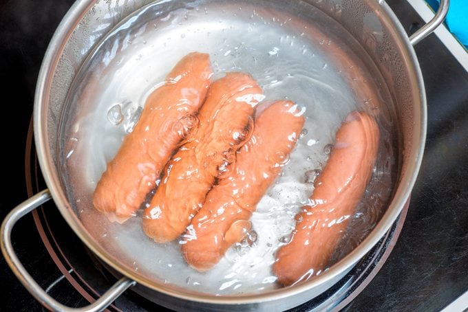hotdogs are boiled in a pan in boiling water, close-up shot