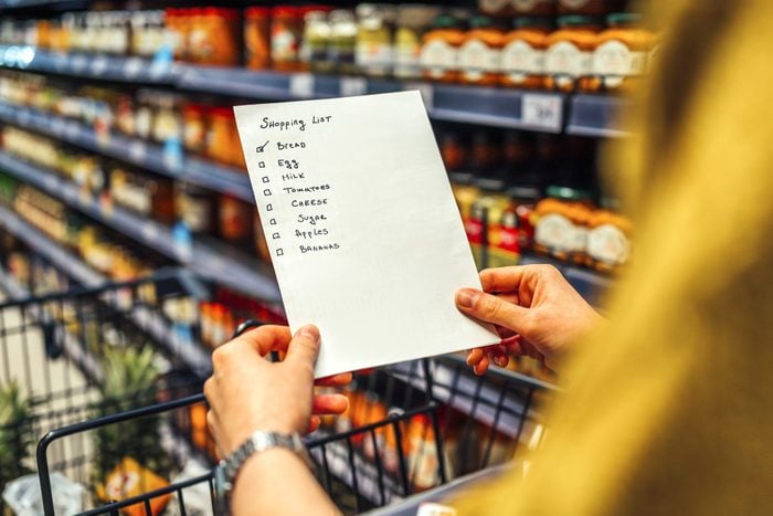 Woman with shopping list in grocery store