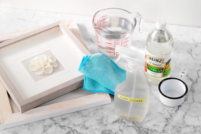 Glass Cleaner ingredients next to framed art On Marble Surface