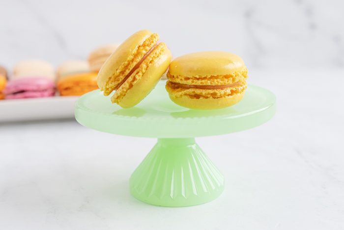 Lemon macaroon on a green plate with a stand