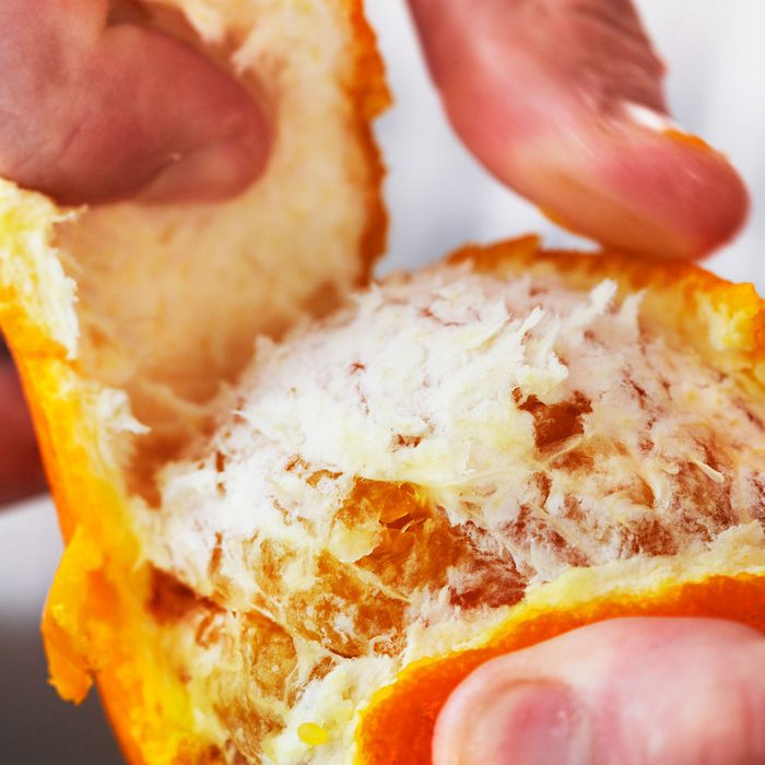 Man peels back Peel off of an Orange
