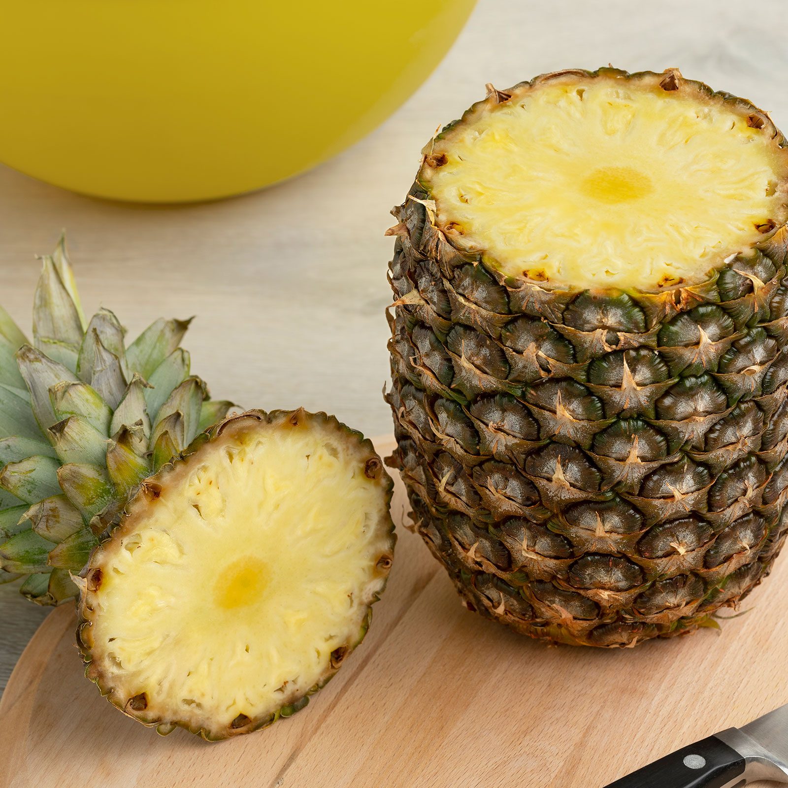 Fresh Tropical Pineapple with top cut off On A Cuttingboard