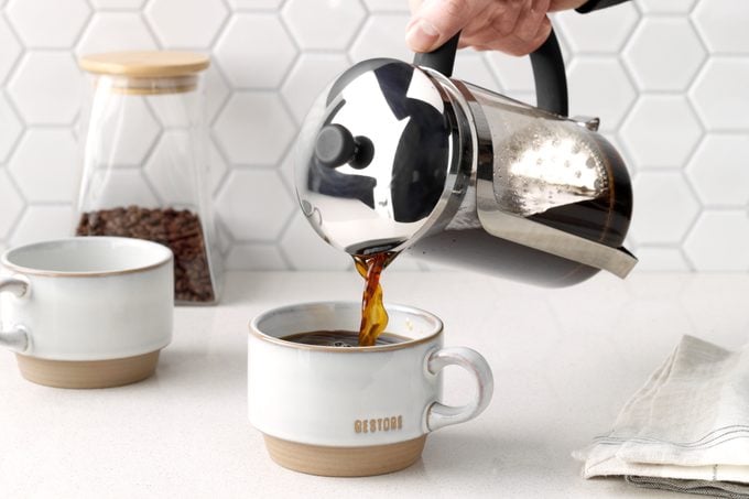pouring French press coffee into a mug