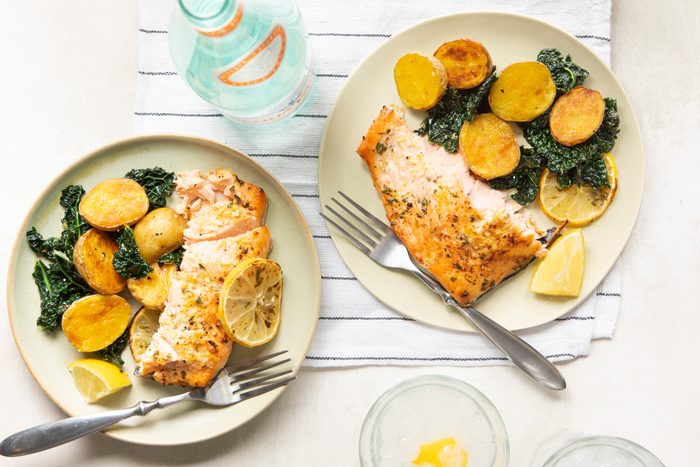 two plates with salmon and a side of potatoes