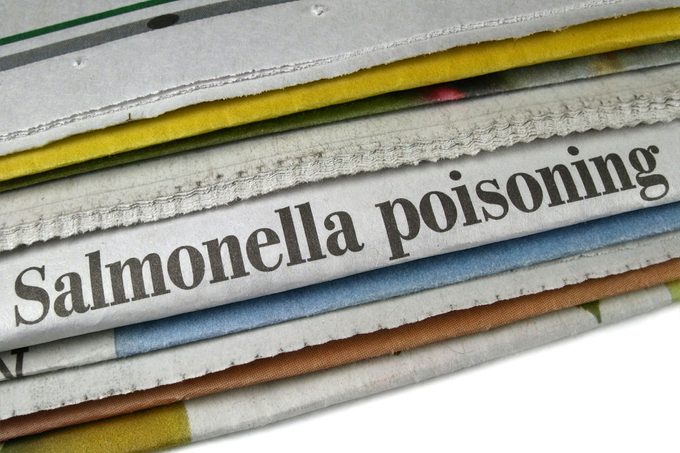 Newspaper Headline "Salmonella Poisoning" in stack of papers