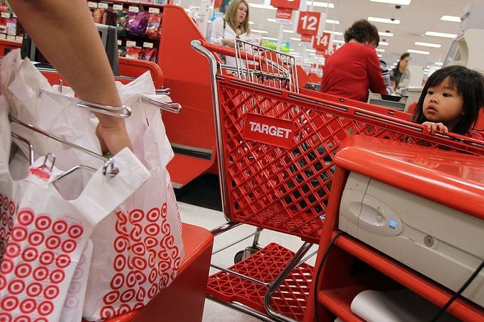 Young Girl Watches Cashier bag groceries at a target store