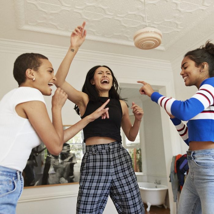 Young friends dancing and enjoying in bedroom