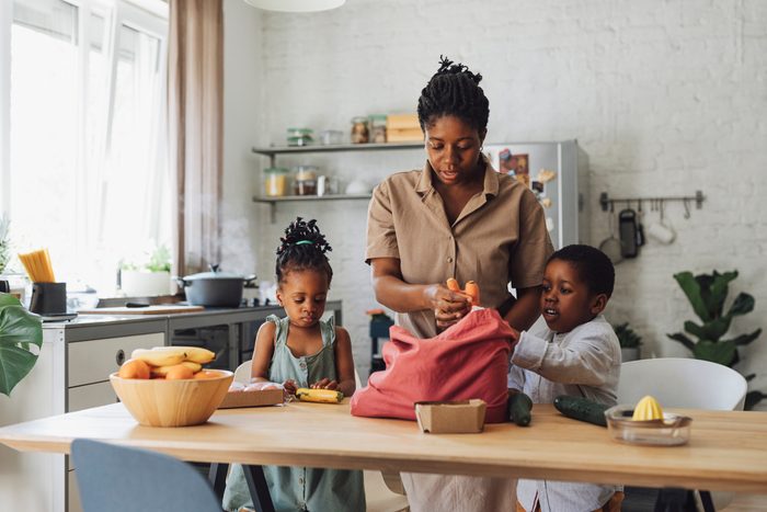 Mother, Daughter and Son Preparing Vegetables for Lunch at a Kitchen Table