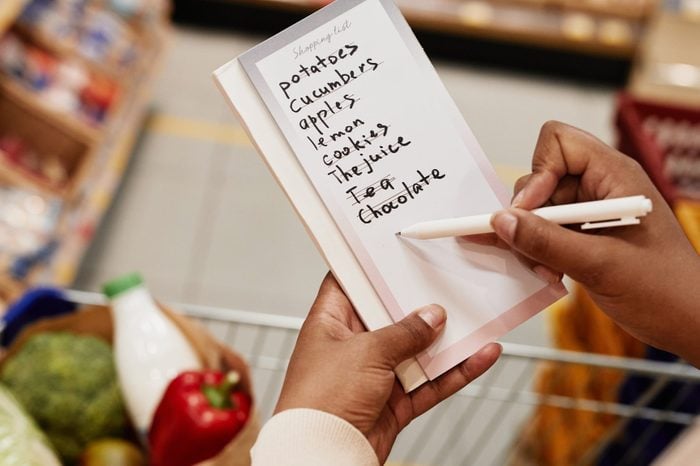 Woman Crossing Items of Shopping List