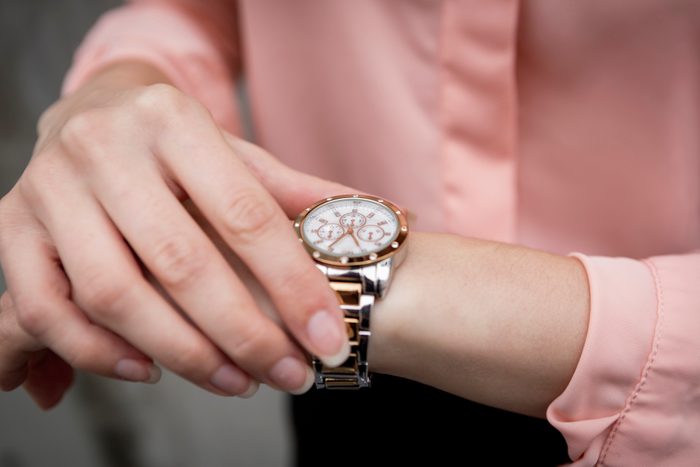 Portrait of a young businesswoman looking on her wristwatch