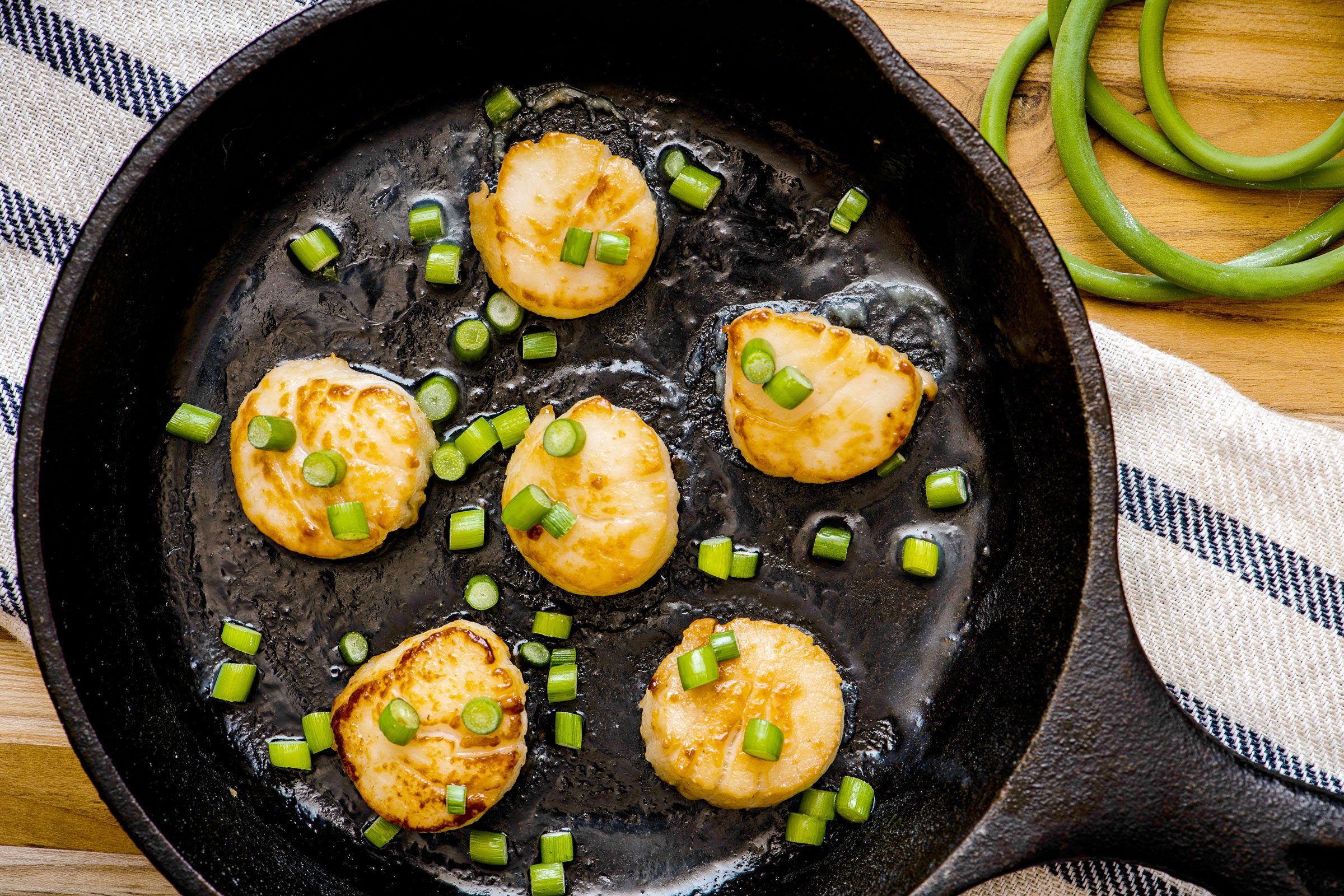 garlic scapes and scallops in a cast iron pan