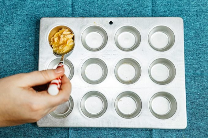 scooping cat cake mixture into a muffin pan