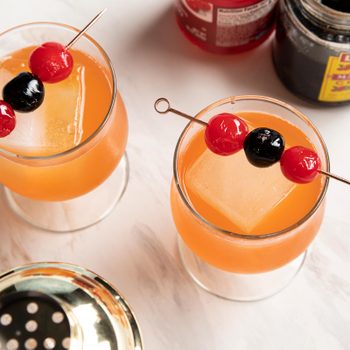 Rum Punch in two glasses topped with cherries