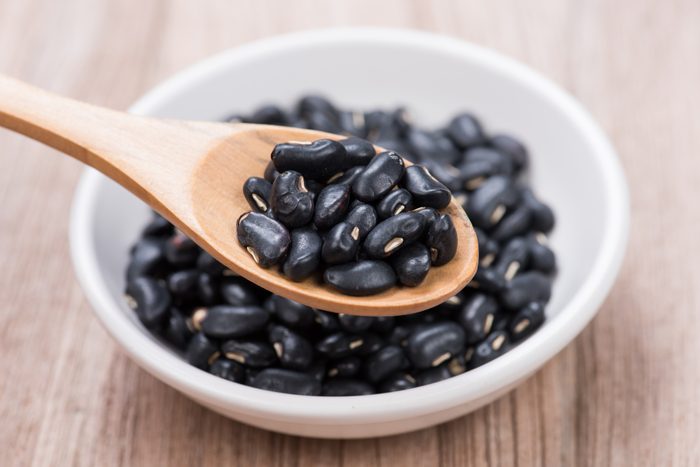 Black Beans in wooden spoon with seramic bowl