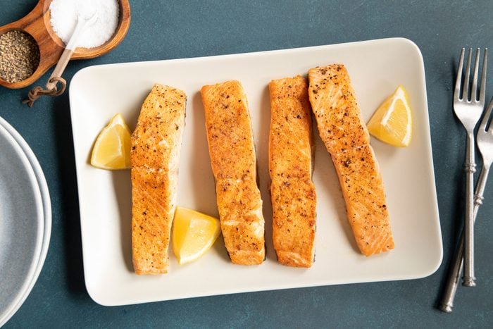 Cooked Air Fryer Salmon served in a white plate with lemon