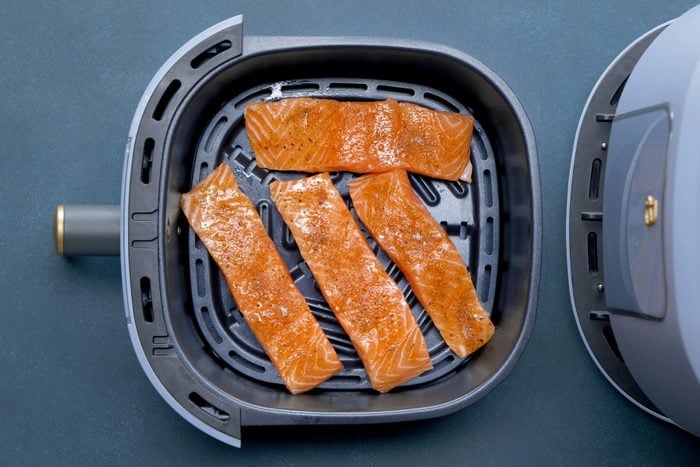 Salmon fillets in a single layer in the air-fryer baske