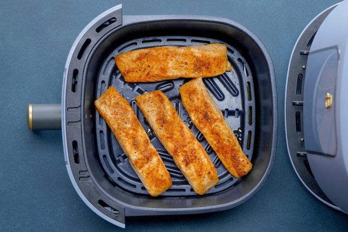 cooked Salmon fillets in a single layer in the air-fryer basket