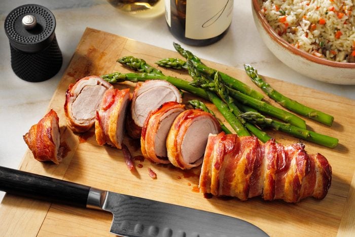 Bacon Wrapped Pork Tenderloin sliced on a cutting board