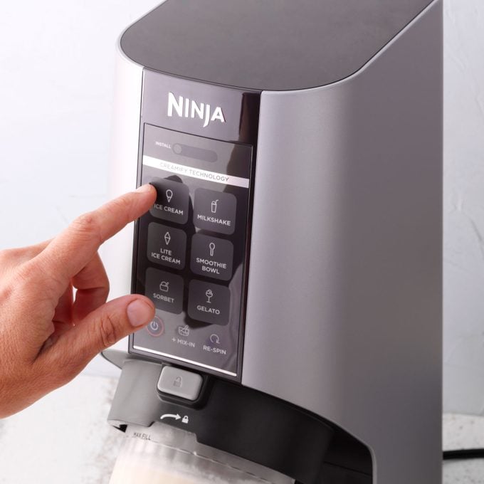 finger pressing button on the Ninja Creami