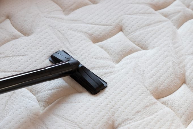 cleaning mattress by vacuum cleaner. dust mites on bed, texture. concept : allergy in bed room.