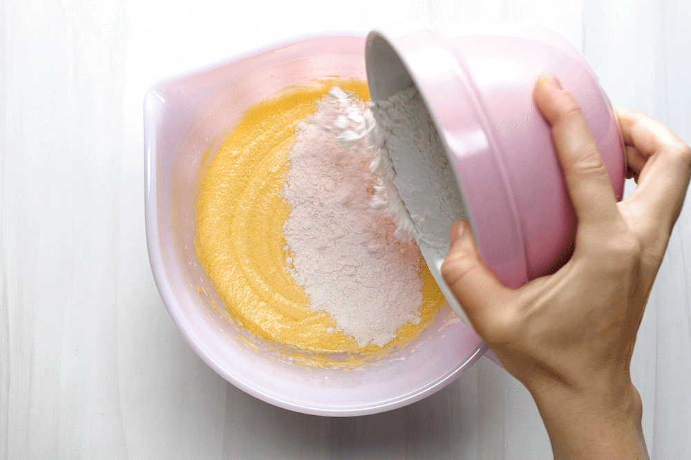 hand combining wet and dry ingredients and beating the batter