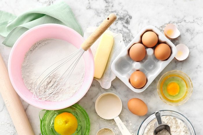 Flour, eggs, butter and baking supplies on a kitchen counter