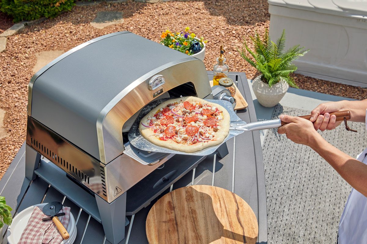Putting pizza in 3-in-1 Cuisinart Pizza Oven