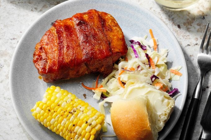 Bacon Wrapped Pork Chops with bun and corn