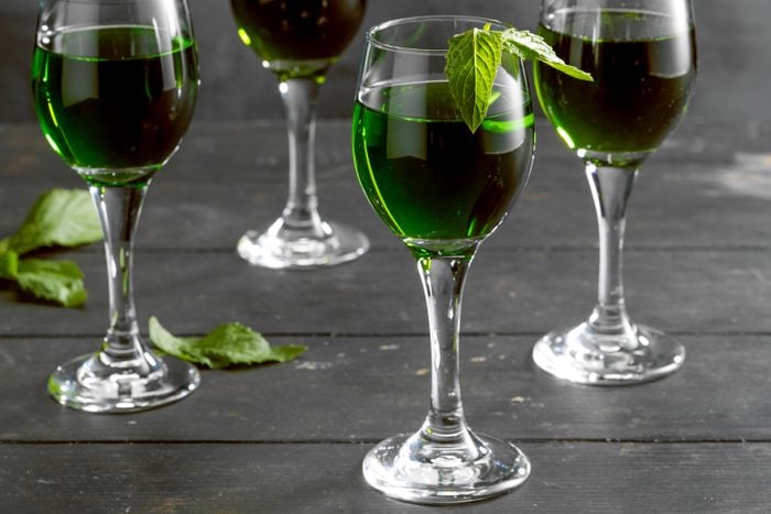 Homemade Creme De Menthe in Wine Glasses on Wooden Surface