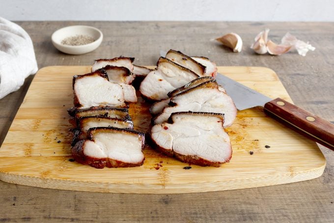 Pork Belly cut into slices on a wooden cutting board