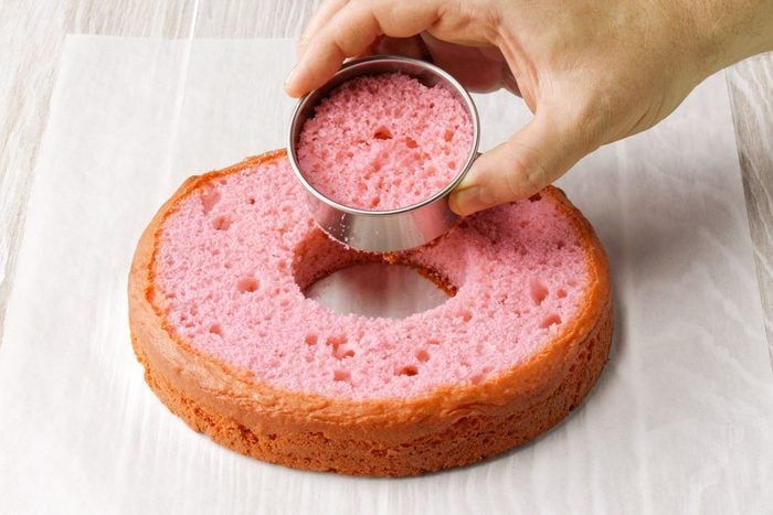 Hand Cutting Circle In Surprise Cake pink layer