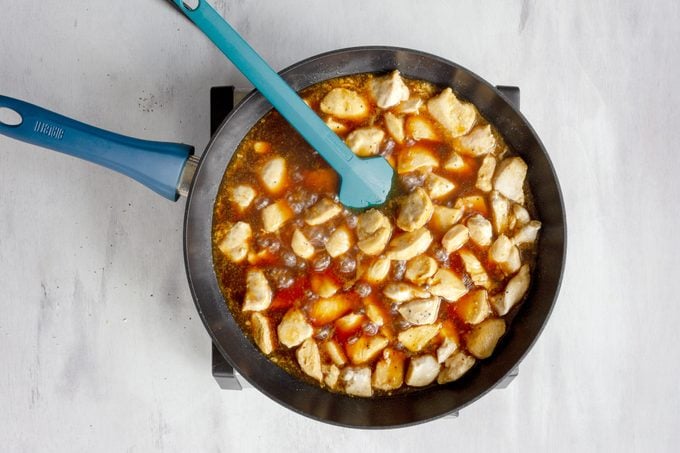 Teriyaki Chicken in a skillet with a teal rubber spatula