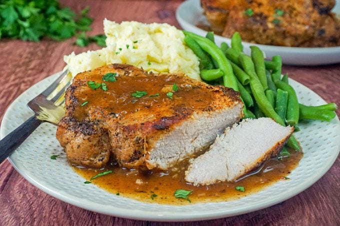 Instant Pot Pork Chops served with Garlic Mashed Potatoes and Green Beans in Plate