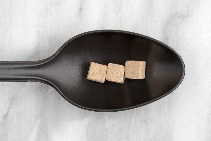 Beef flavored bouillon cubes on a black spoon