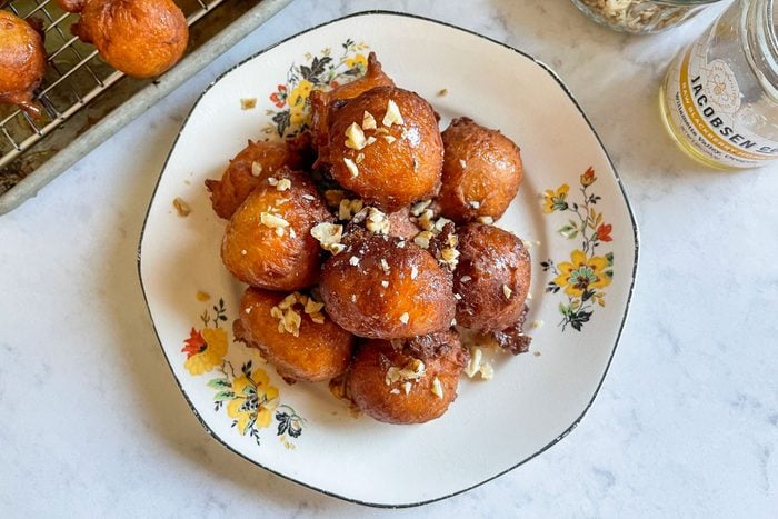 Loukoumades (Greek Doughnuts With Honey) garnished with Crushed Nuts in Plate