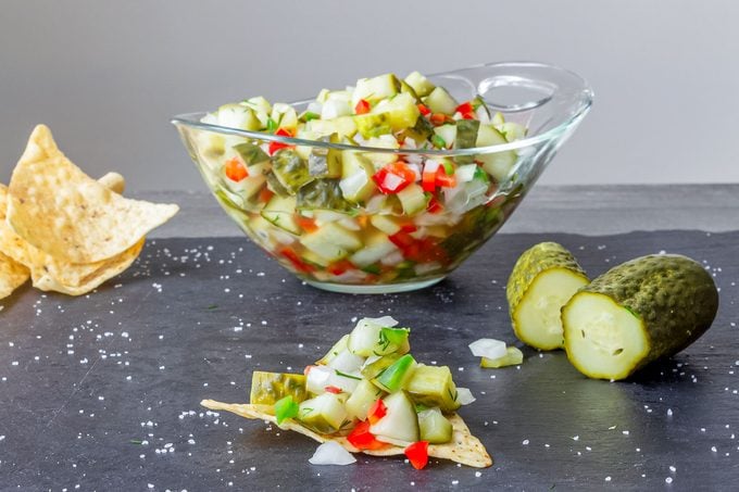 Pickle De Gallo, Glass bowl of chopped pickle relish with tortilla chips and pickles