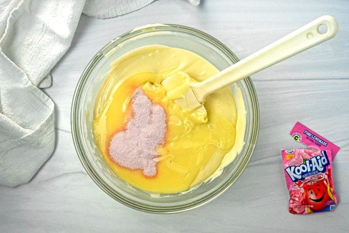 Mixing Melted White Chocolate with Pink Lemonade Powder and Sweetened Condensed Milk in a Glass Bowl