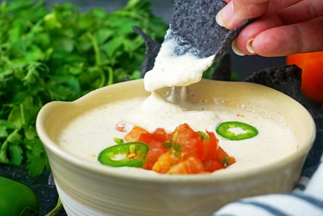 dipping chip in Cottage Cheese Queso
