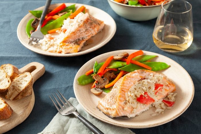 stuffed salmon on two plats with a side of mixed veggies