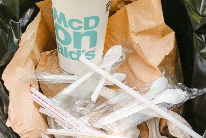 Plastic McDonald's Cup, Spoons, Straws, and Paper Bag Thrown in to Black Trash Bag and Trash Can