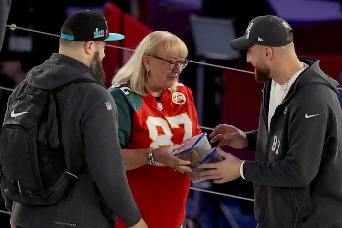Mother Donna Kelce (C) gives cookies to her son's Jason Kelce (L) #62 of the Philadelphia Eagles and Travis Kelce (R) #87 of the Kansas City Chiefs during Super Bowl LVII Opening Night presented by Fast Twitch at Footprint Center on February 06, 2023 in Phoenix, Arizona