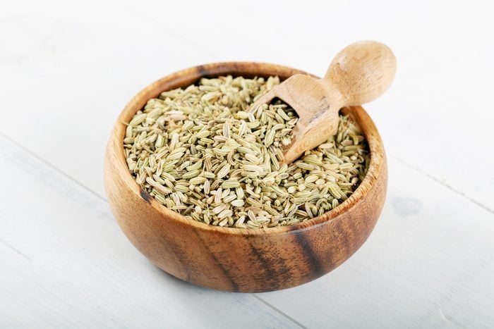 Dried Anise Seed or Aniseed in wooden bowl on white background.