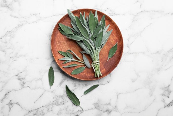fresh sage on a wooden plate on a marble background