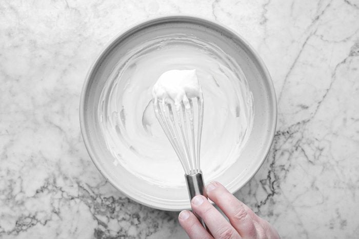 Beating the whipping cream in a large bowl with a spatula