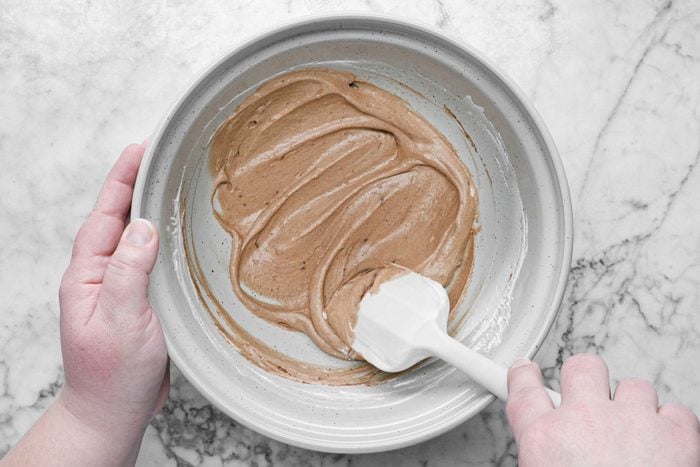 Mixing the chocolate mixture and cream in a large bowl with a spatula